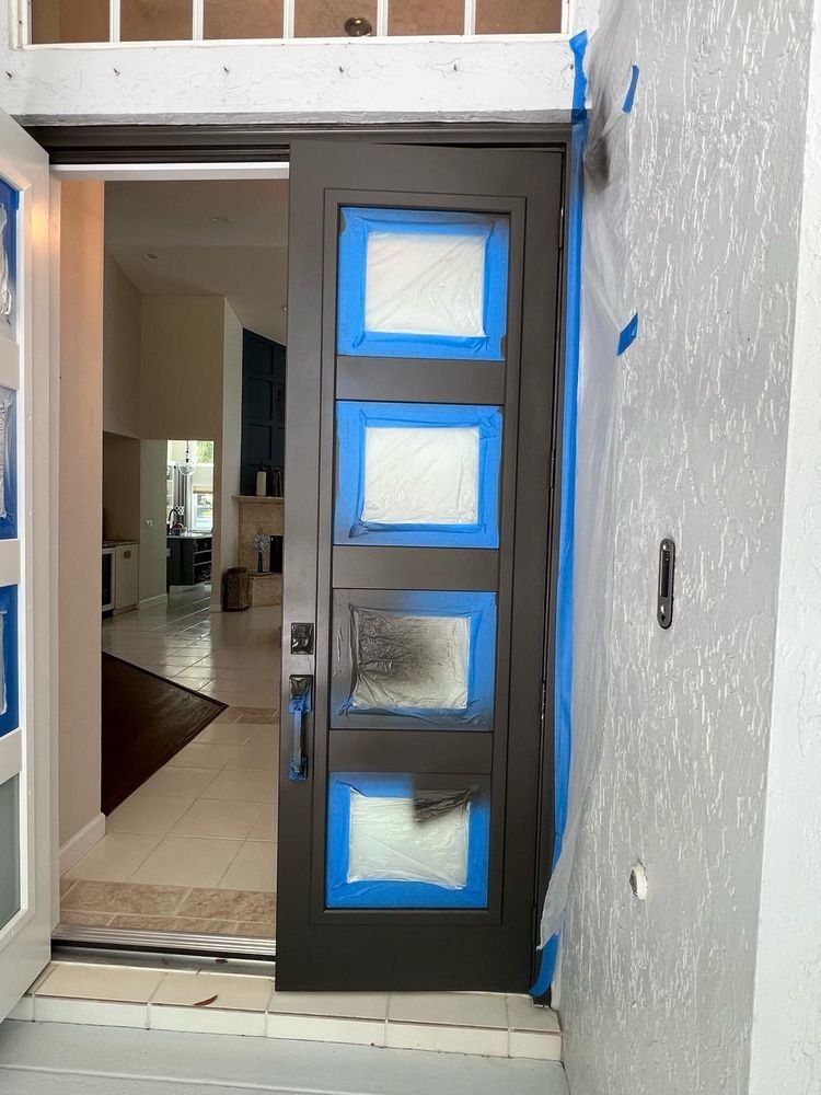 Exterior front door dark bronze spray setup with masked glass in Jupiter FL
