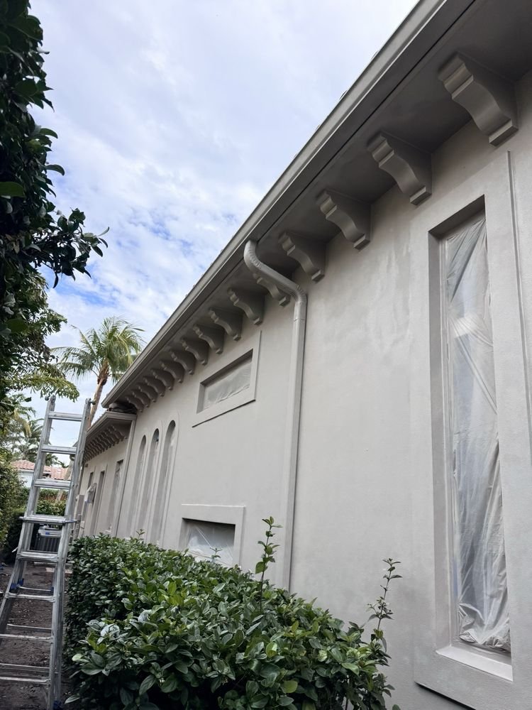 Protective masking over windows and corbels on exterior stucco wall in Jupiter FL