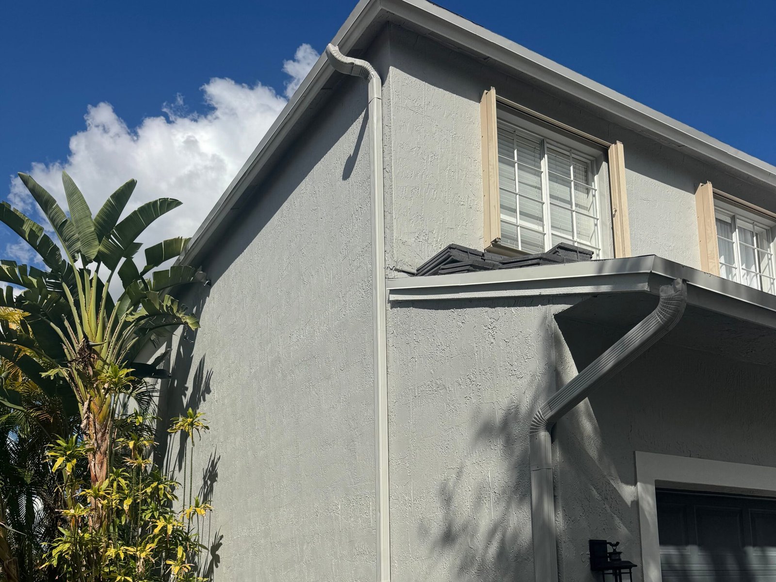 Second-story exterior stucco repaint with window shutters in Jupiter FL